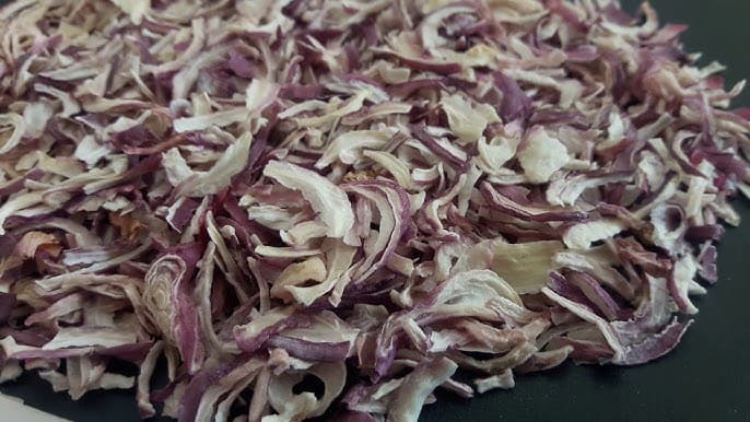 Dehydrated red onion flakes showing crisp texture and deep-red color